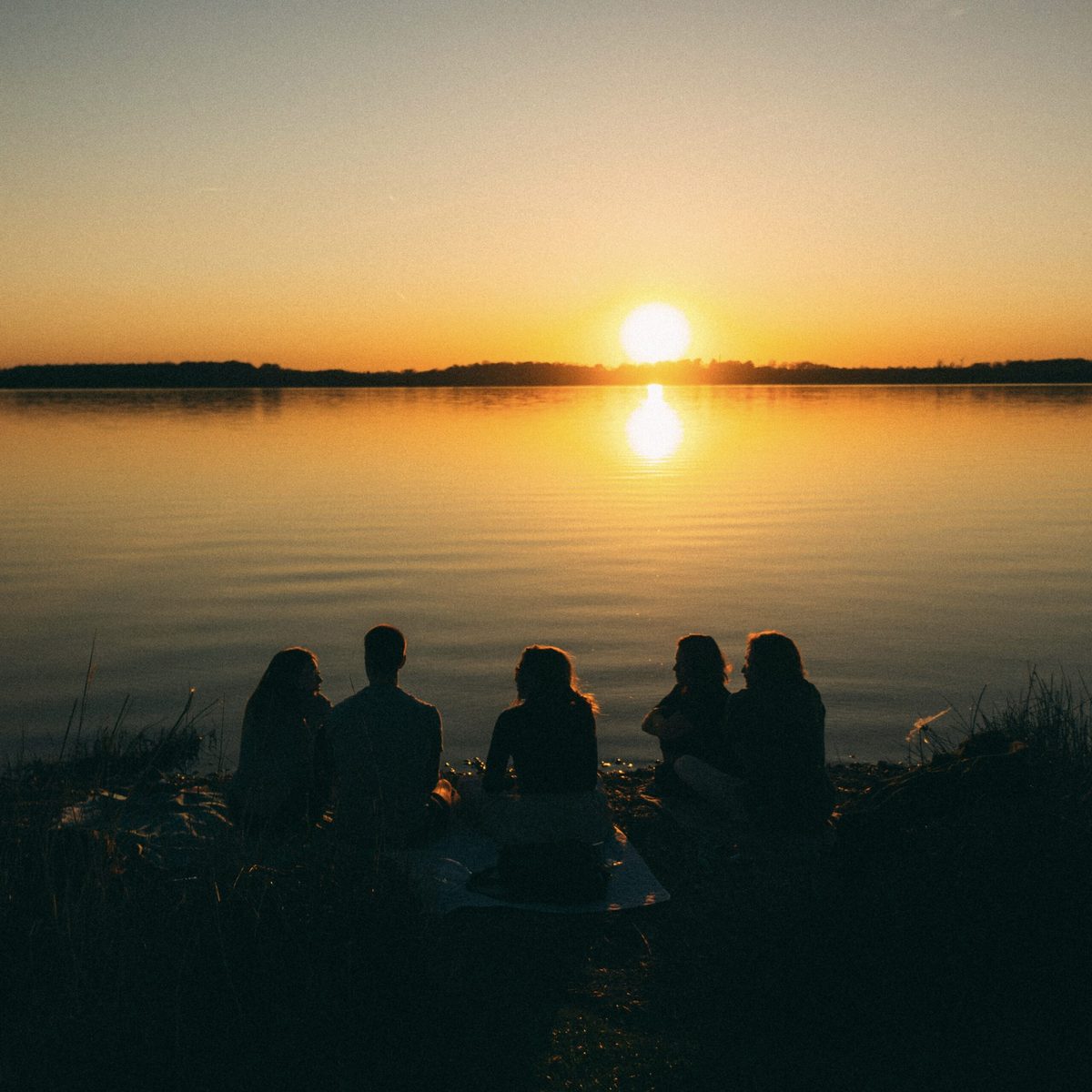 Familie genießt Sonnenuntergang am Ufer der Ostsee