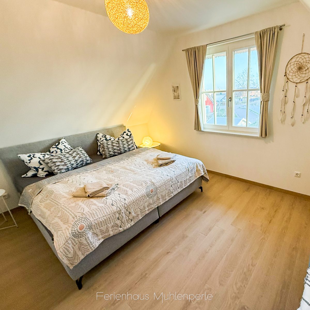 Schlafzimmer mit Boxspringbett im Ferienhaus Mühlenperle