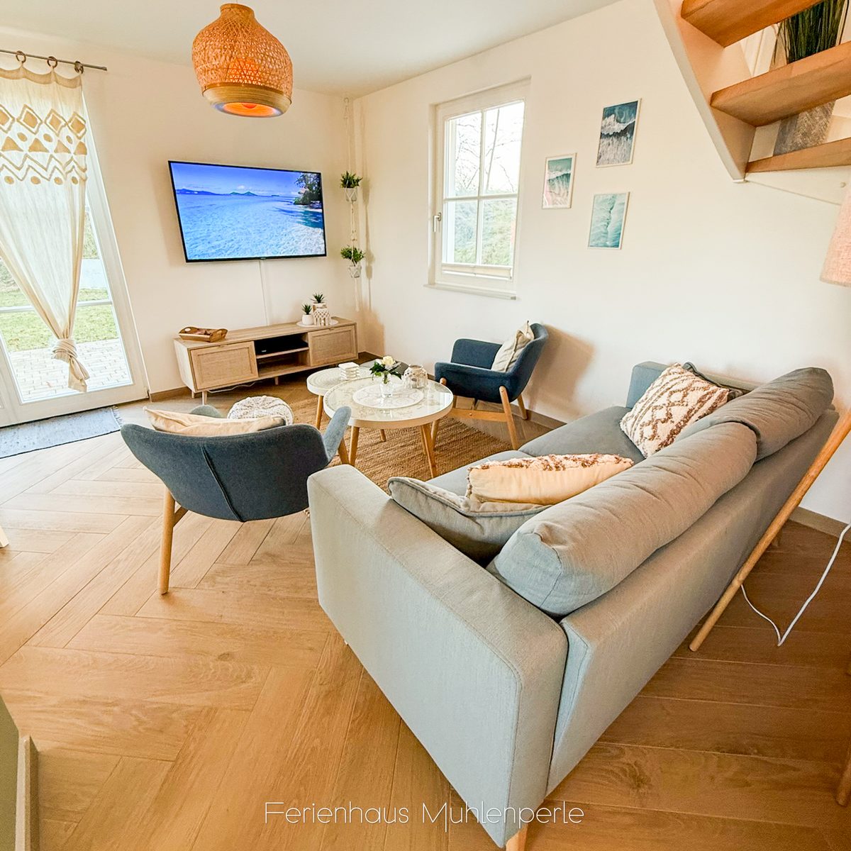 Wohnbereich mit Sofa, Sesseln und Fernseher im Ferienhaus Mühlenperle