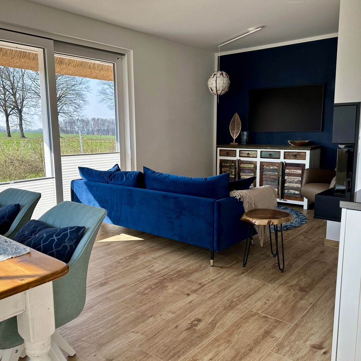 Blick von der Küche ins Wohnzimmer mit blauem Sofa