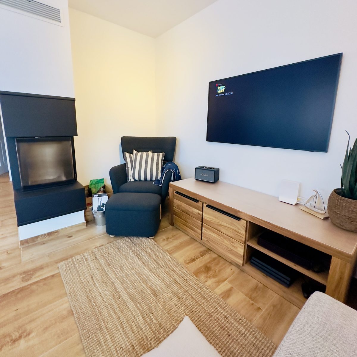 Wohnzimmer mit Kamin, Sofa und Fernseher im Ferienhaus KiteZeit